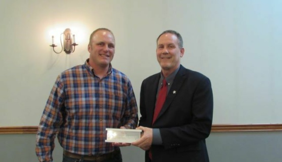 Coldwater Young Farmer Dusty Uhlenhake accepting a plaque from Tri Star Director Tim Buschur. 